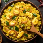 Anjappar Style Egg Fried Rice Recipe, a top-down view of yellow rice with egg and onions in a brown bowl, surrounded by spices.