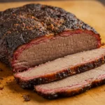 beef bouillon powder for brisket recipe: Close-up of a sliced beef brisket on a wooden board.