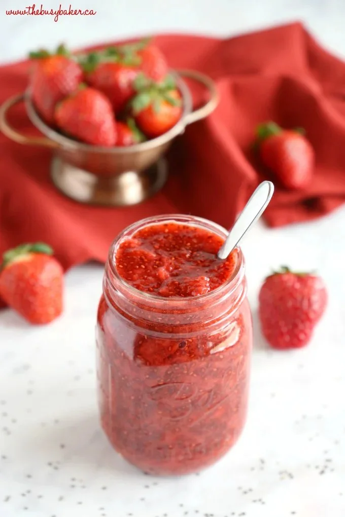 3-ingredient strawberry chia jam served in a jar with fresh strawberries