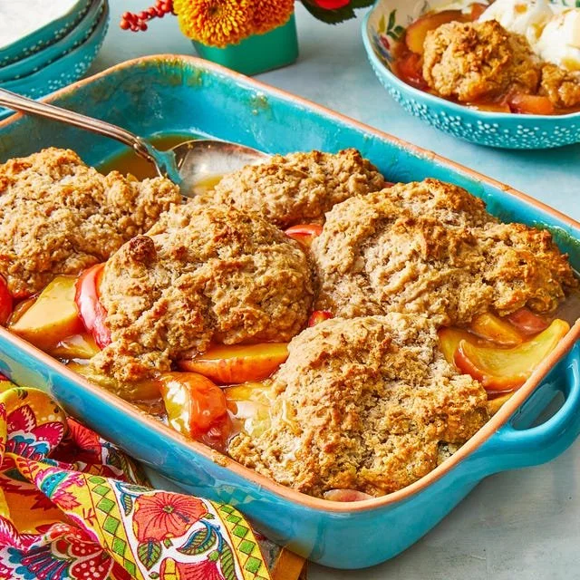 Homemade apple cobbler served in a dish, topped with crisp crumble.