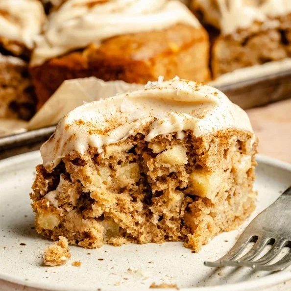 Apple snacking cake with salted brown butter cream cheese frosting on a plate.