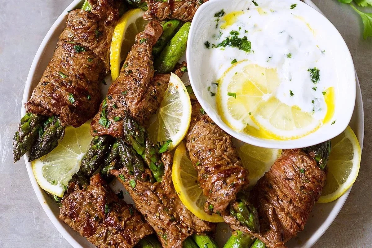 Asparagus and steak fajita roll-ups served on a plate