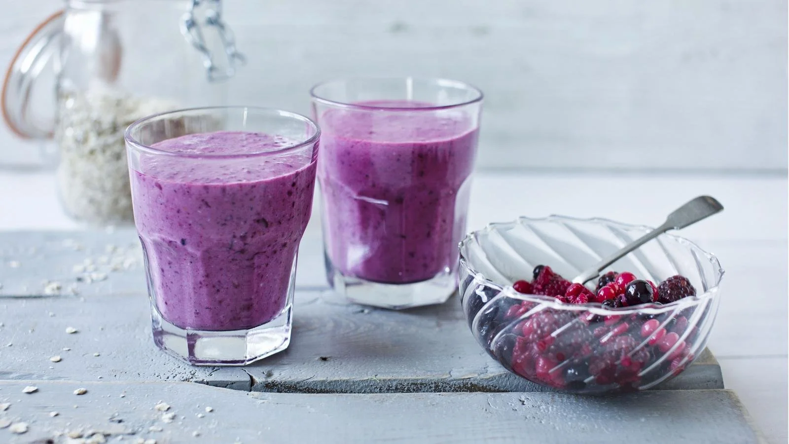 Blackberry apple crumble smoothie in a glass with a sprinkle of oat topping.