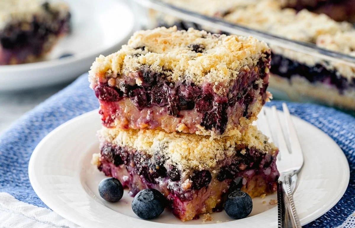 Delicious blueberry crumb bars with a buttery crumble topping on a plate.