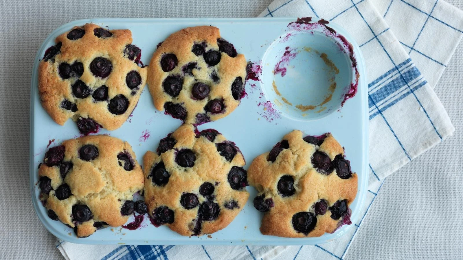 Freshly baked blueberry muffins with a golden brown top and juicy berries