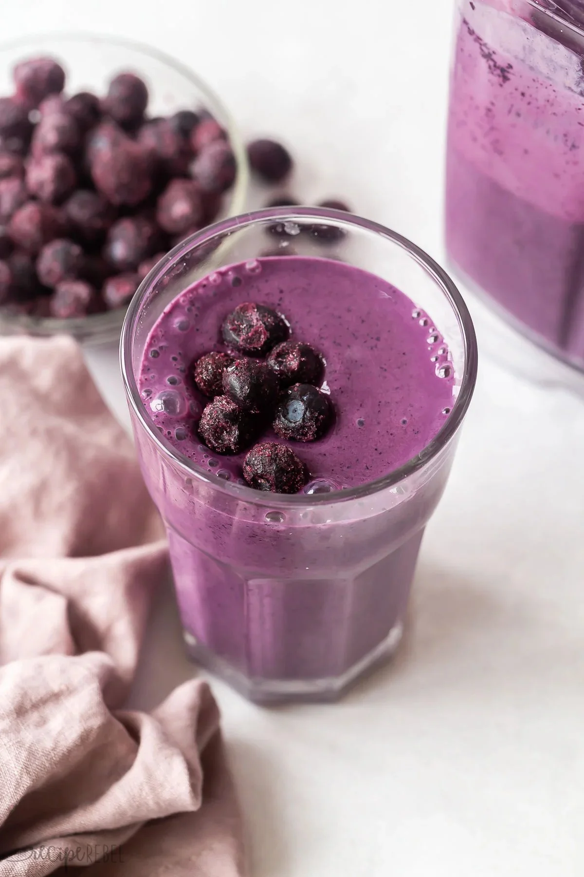 Fresh blueberry smoothie served in a glass with blueberries on top