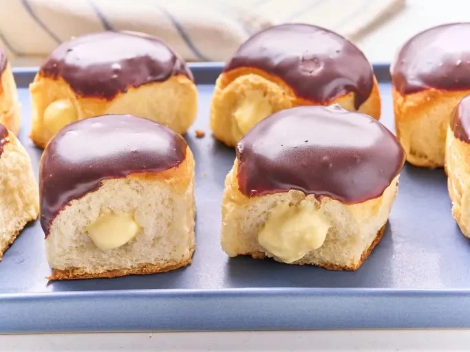 Delicious Boston Cream Hawaiian Roll Donuts topped with chocolate glaze.