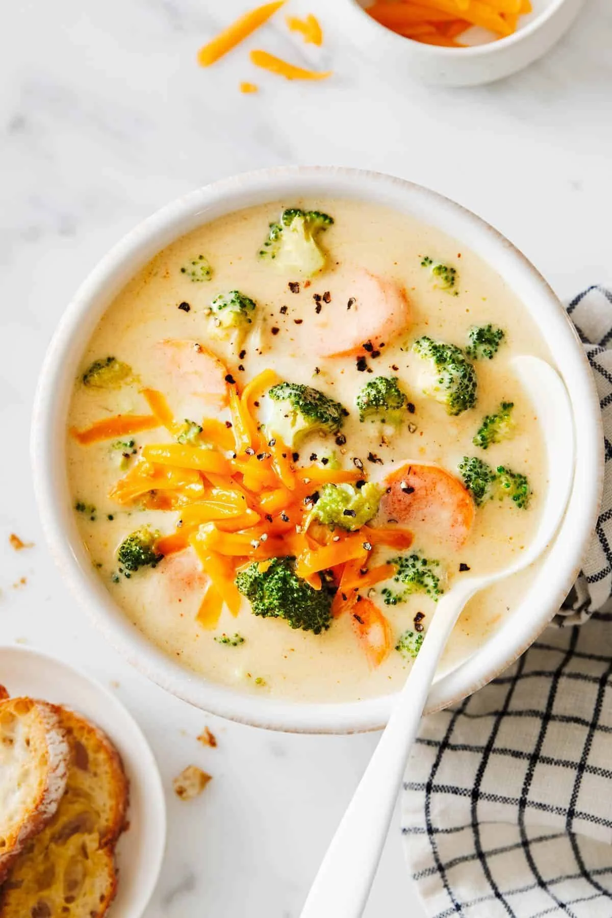 Bowl of creamy Broccoli Cheese Soup garnished with fresh broccoli florets