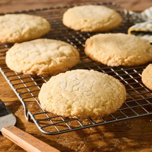 Batch of freshly baked brown butter sugar cookies on a cooling rack