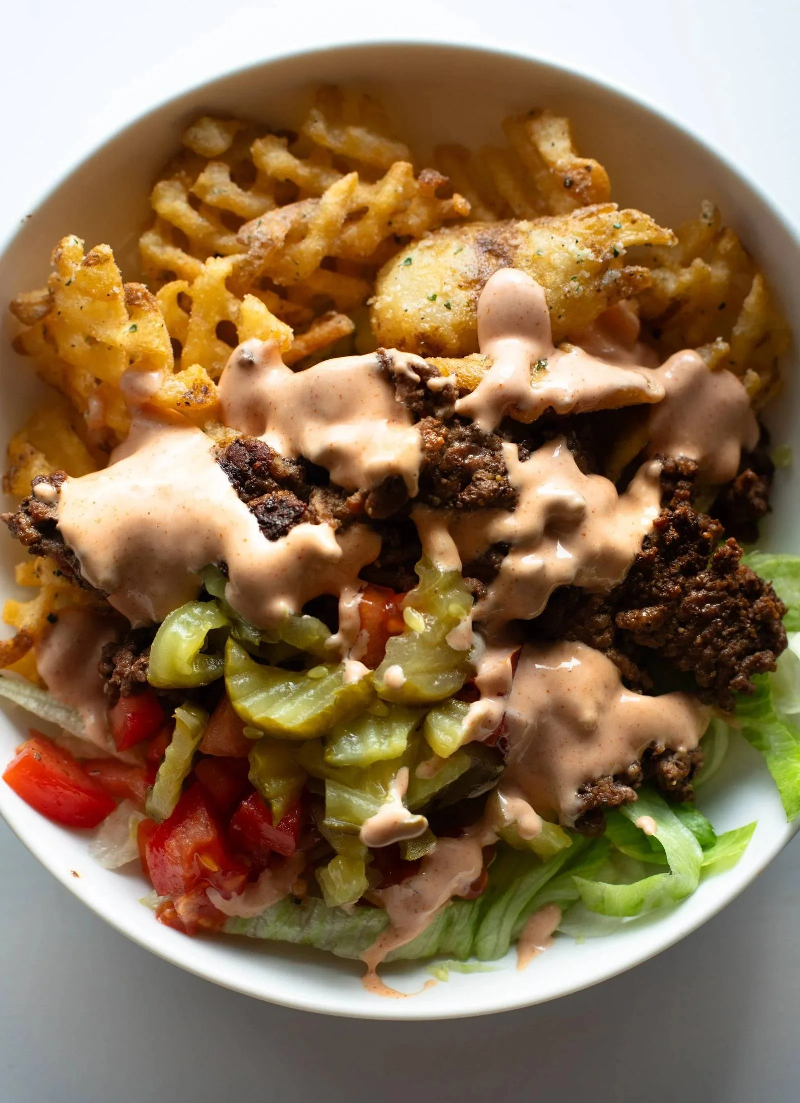 Delicious burger bowls with creamy sauce and crispy ranch fries