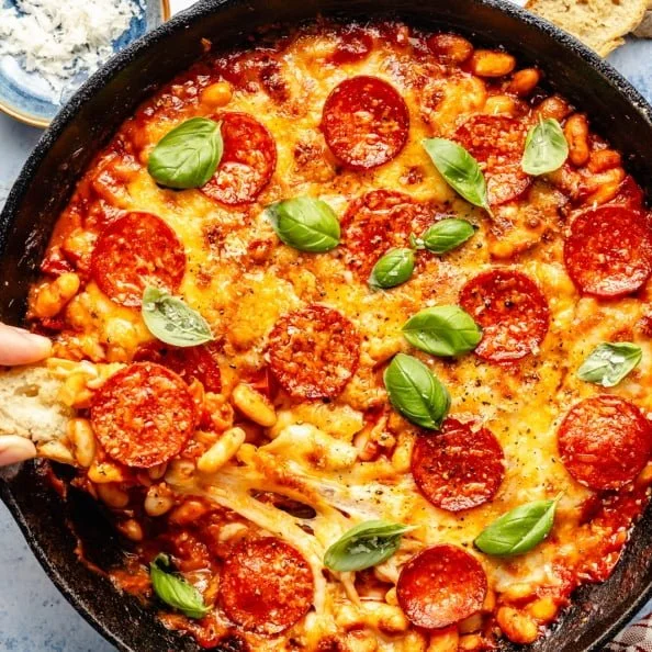 Burst cherry tomato and pepperoni white bean bake in a serving dish