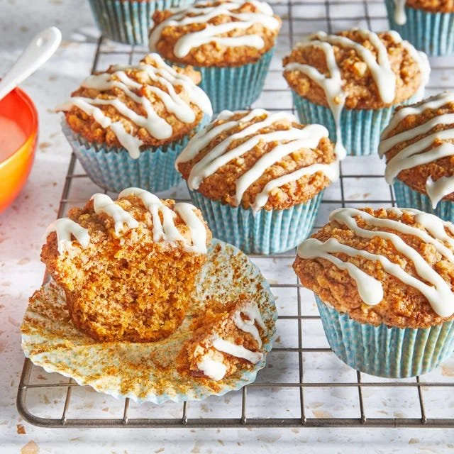 Freshly baked carrot cake muffins with cream cheese frosting on top