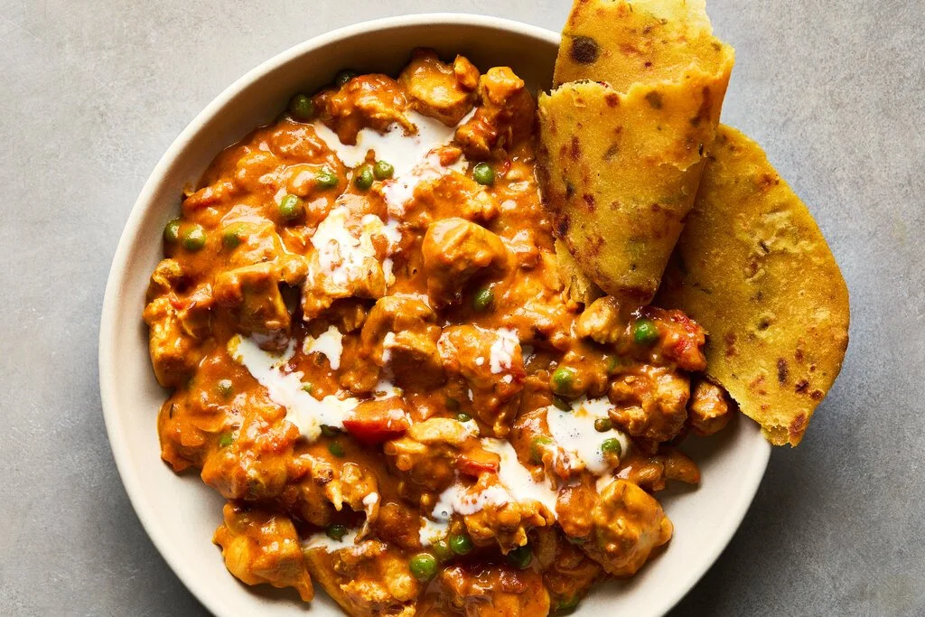 Delicious Cashew Butter Chicken Korma served with rice and garnished with cilantro.