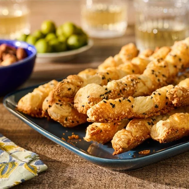 Homemade cheese straws fresh out of the oven, golden and crispy.