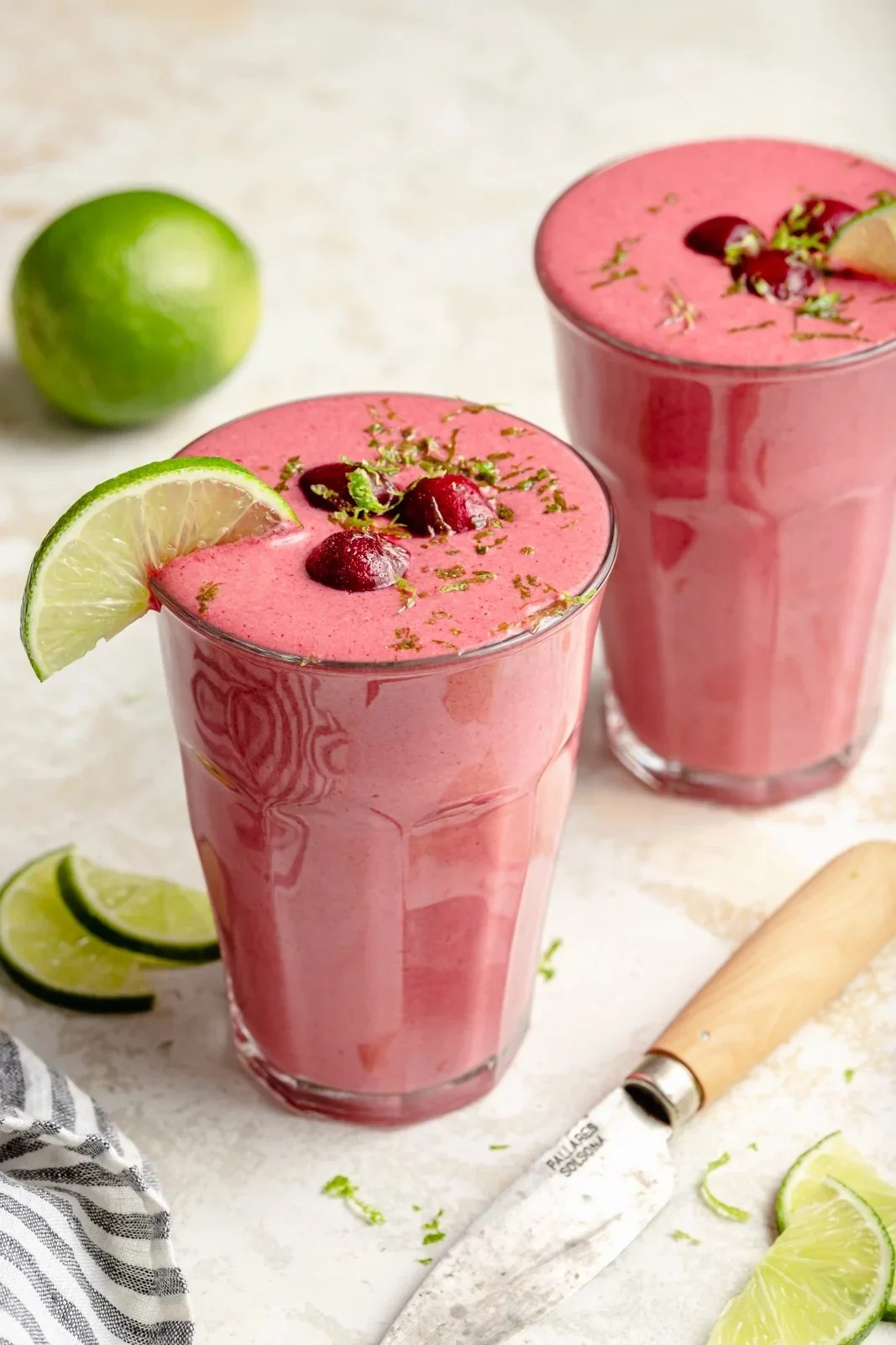 Delicious Cherry Lime Smoothie in a glass with cherries and limes