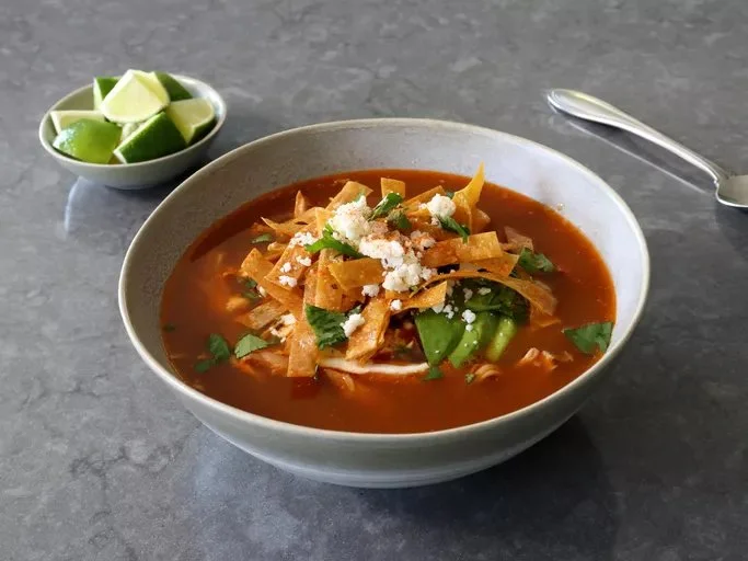 Bowl of delicious Chicken Tortilla Soup with tortilla strips and fresh toppings