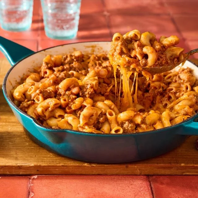 Bowl of Chili Mac and Cheese topped with cheese and herbs