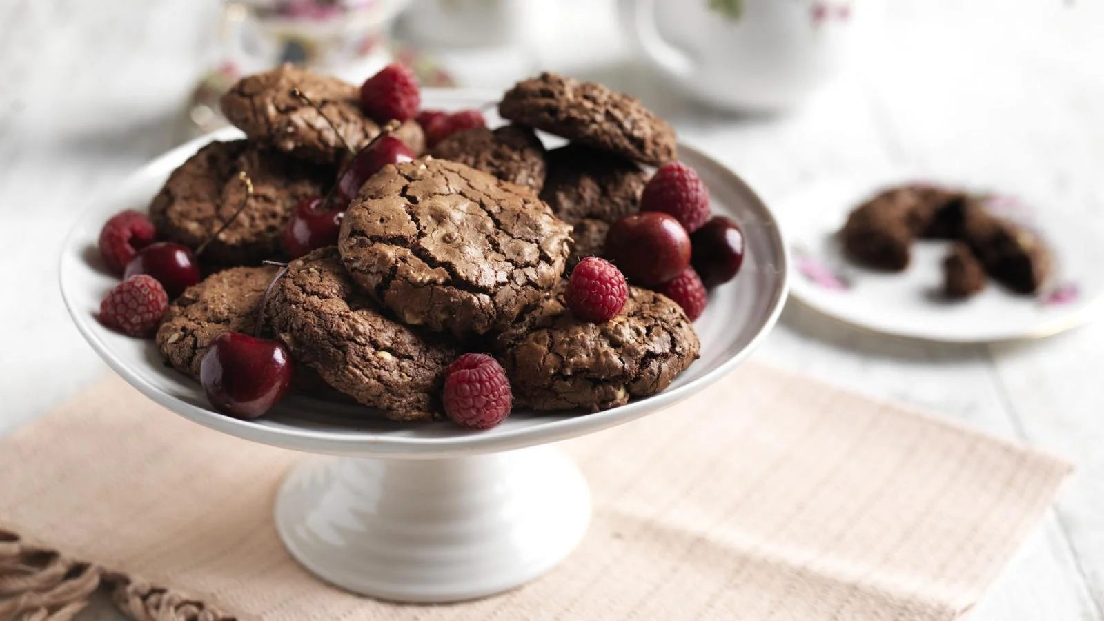Chocolate cookies with scarlet fruit garnished on a plate