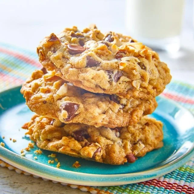 Delicious cowboy cookies with oats, chocolate, and nuts on a wooden surface.