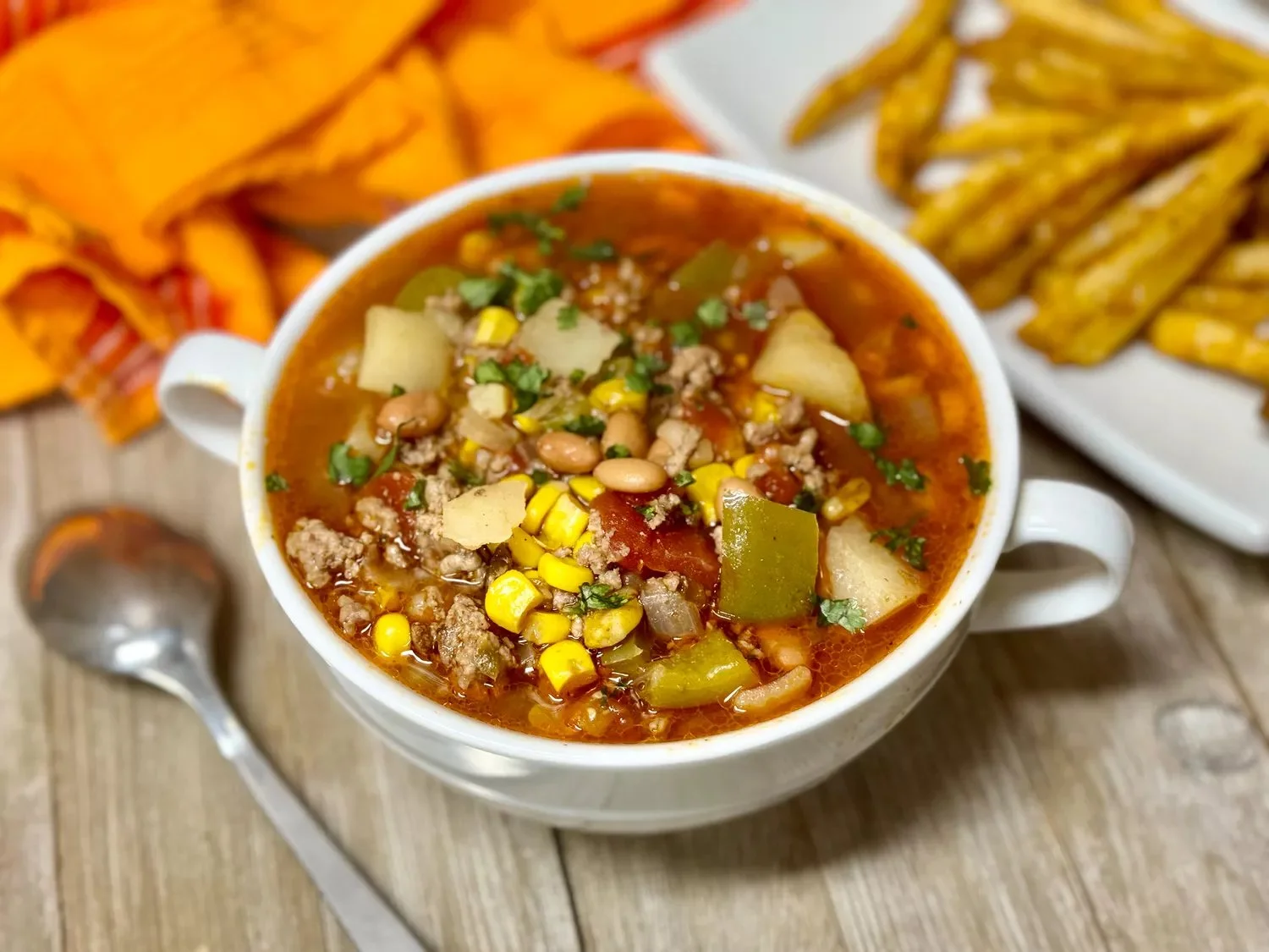 A bowl of hearty Cowboy Soup filled with beans, vegetables, and spices.
