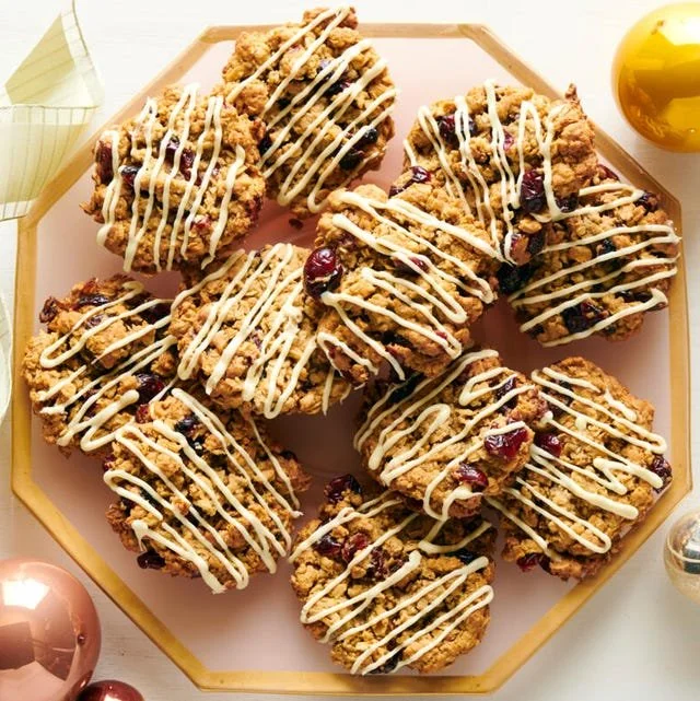 Cranberry Orange Oatmeal Cookies on a wooden platter, garnished with orange slices