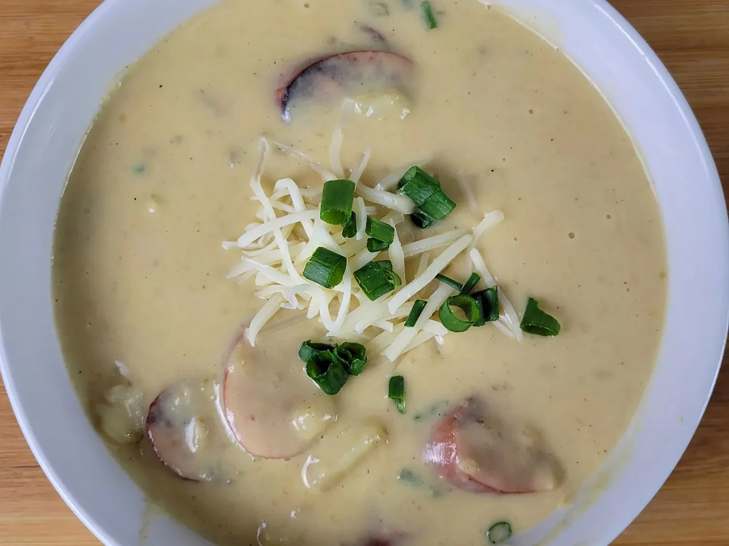 Bowl of creamy Cajun potato soup topped with green onions and spices