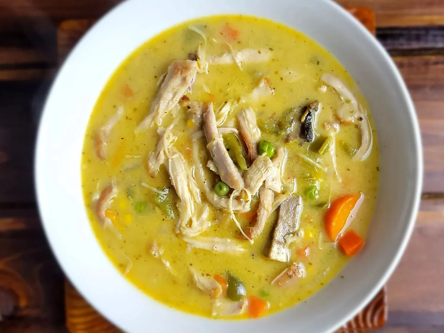 Creamy chicken pot pie soup in a bowl garnished with herbs