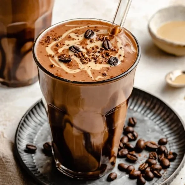 Creamy chocolate coffee date shake topped with whipped cream and cocoa powder