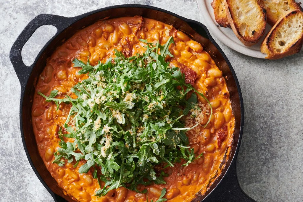Creamy, spicy tomato beans served with fresh greens in a bowl