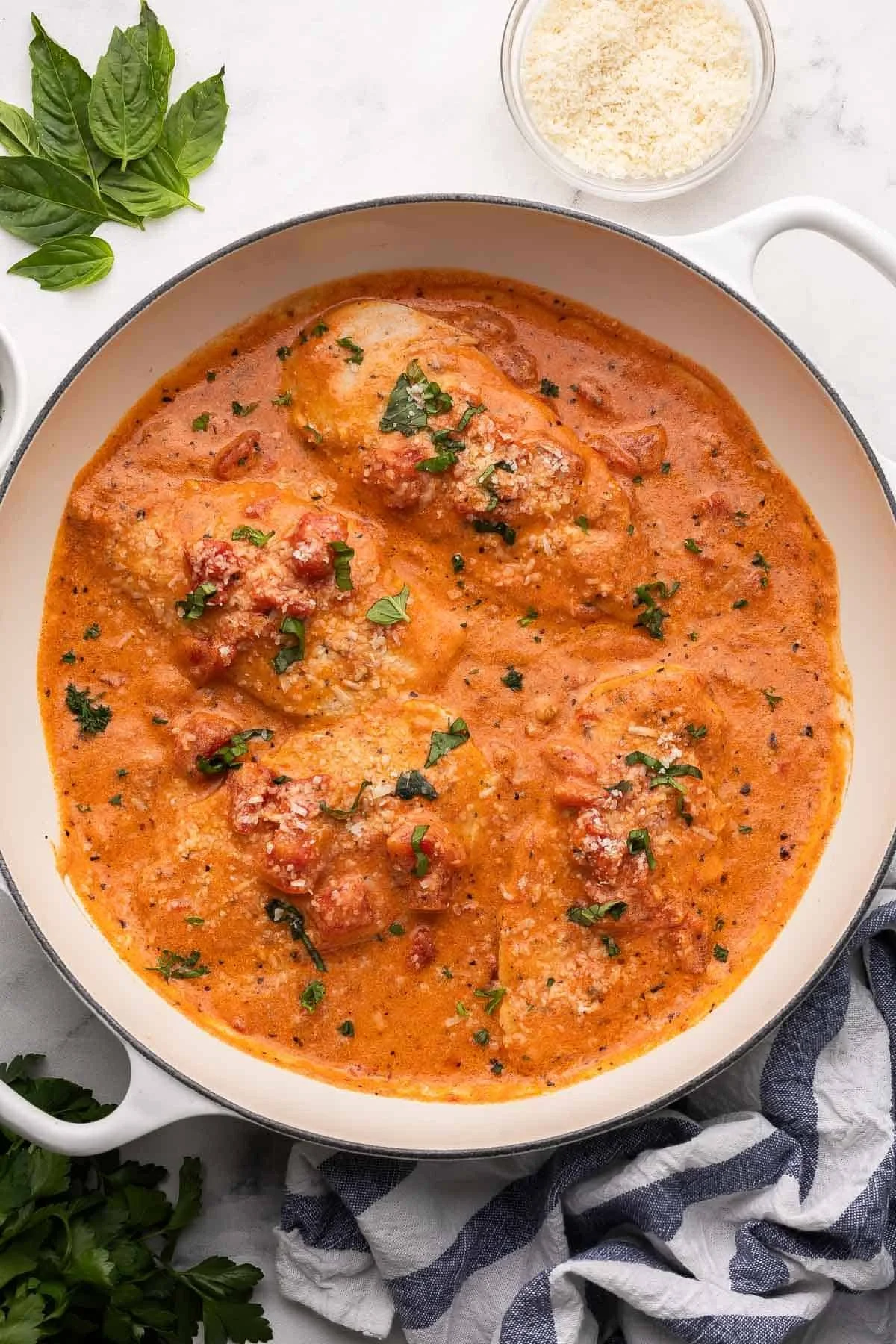Creamy tomato basil chicken served on a plate with fresh basil garnish