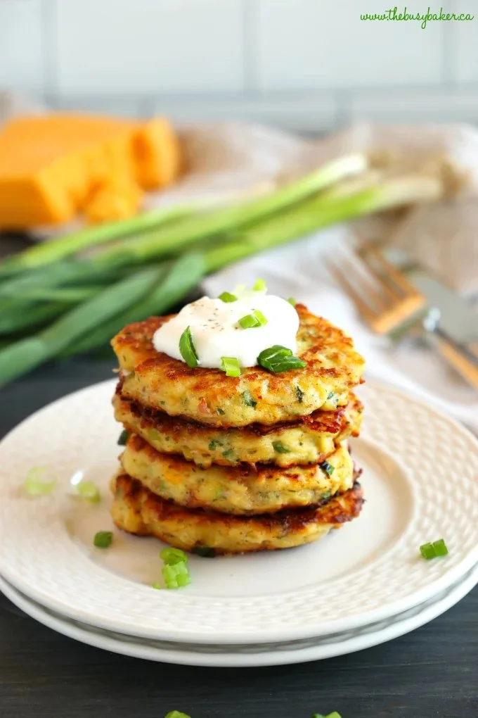 Crispy cheesy mashed potato pancakes served on a plate with toppings.