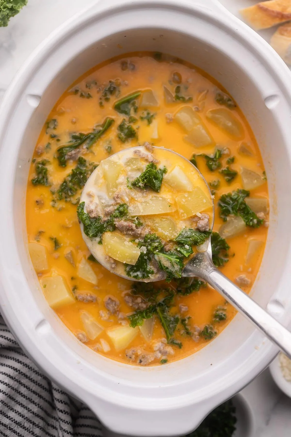 Delicious Crockpot Tuscan Soup in a rustic bowl with fresh ingredients.