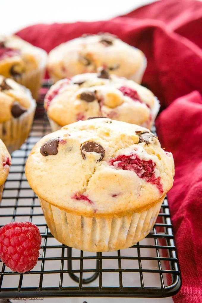 Freshly baked raspberry muffins with chocolate drizzled on top