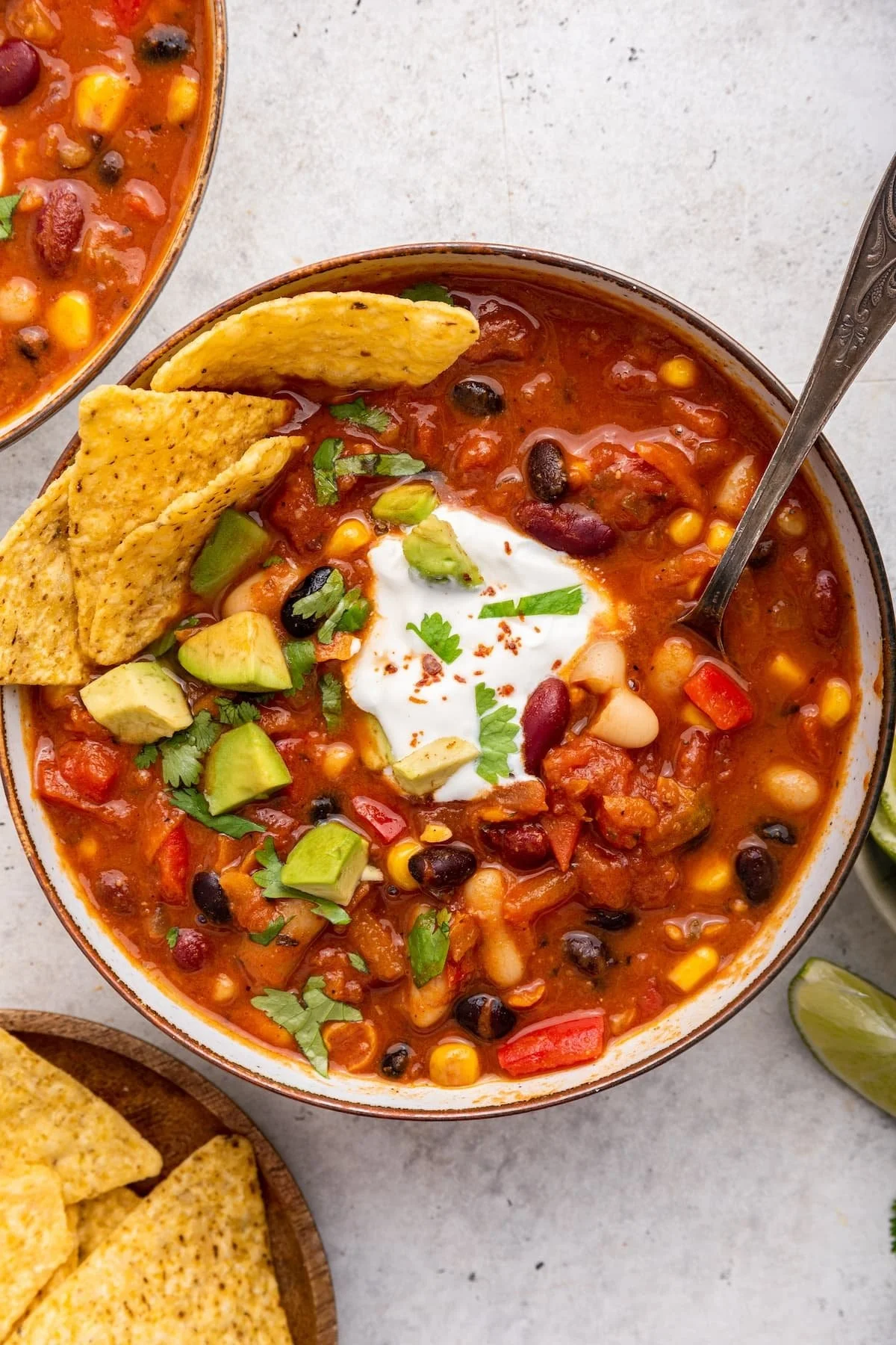 Bowl of easy vegetarian chili topped with fresh herbs and avocado
