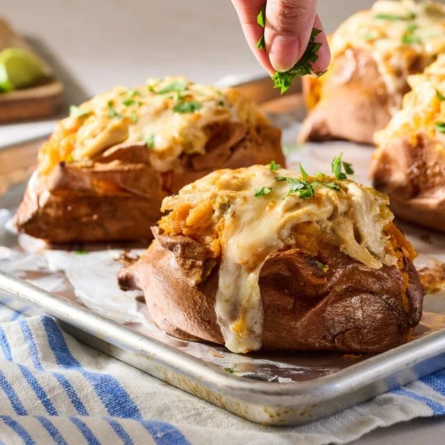 Delicious enchilada stuffed sweet potatoes topped with cheese and cilantro