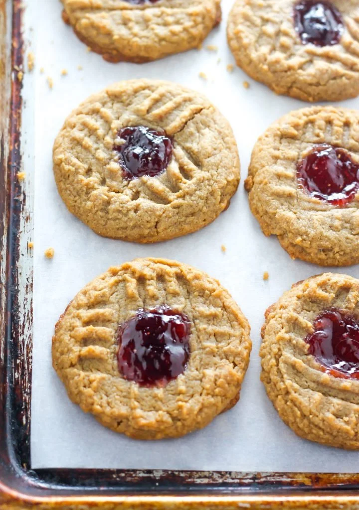 Flourless peanut butter and jelly thumbprint cookies on a plate