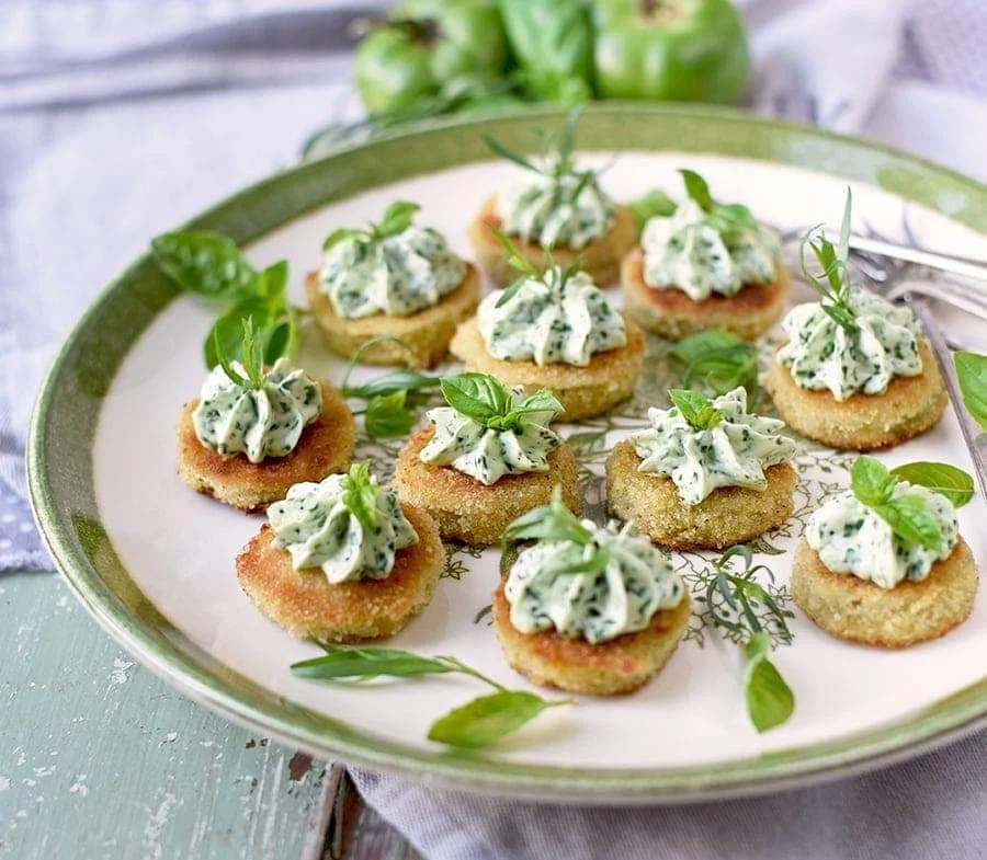 Crispy fried green tomatoes with whipped herb chevre on a plate