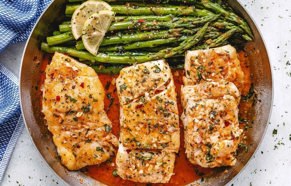 Garlic Butter Cod with Lemon Asparagus in a skillet
