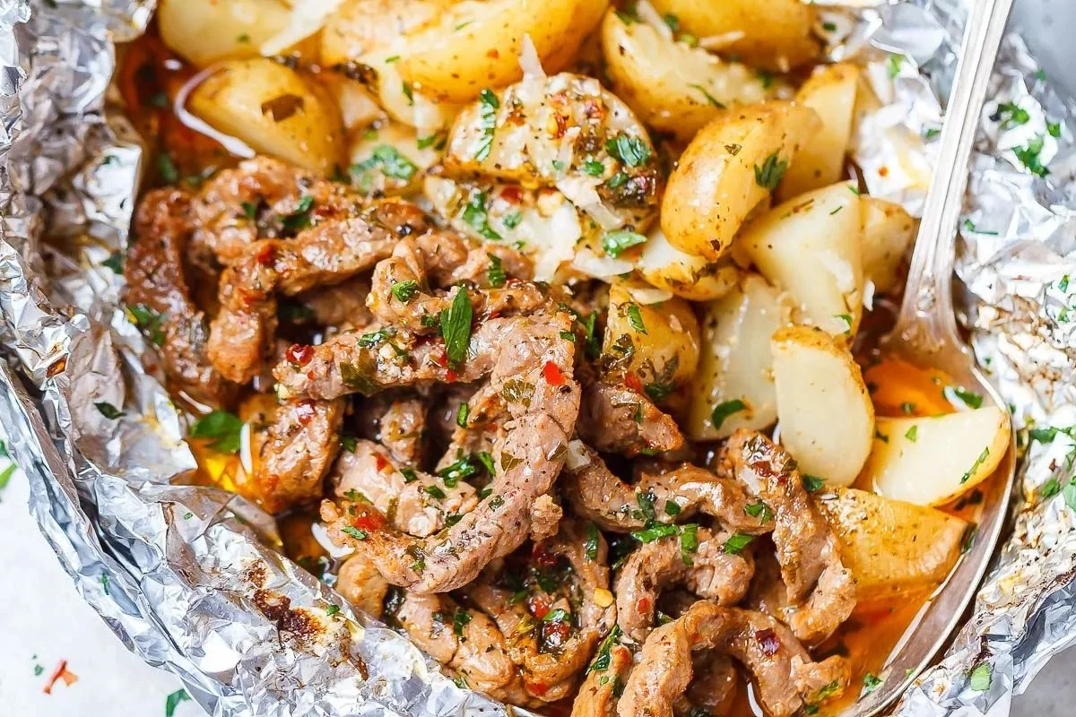 Garlic Butter Steak and Potato Foil Packs served on a grill.