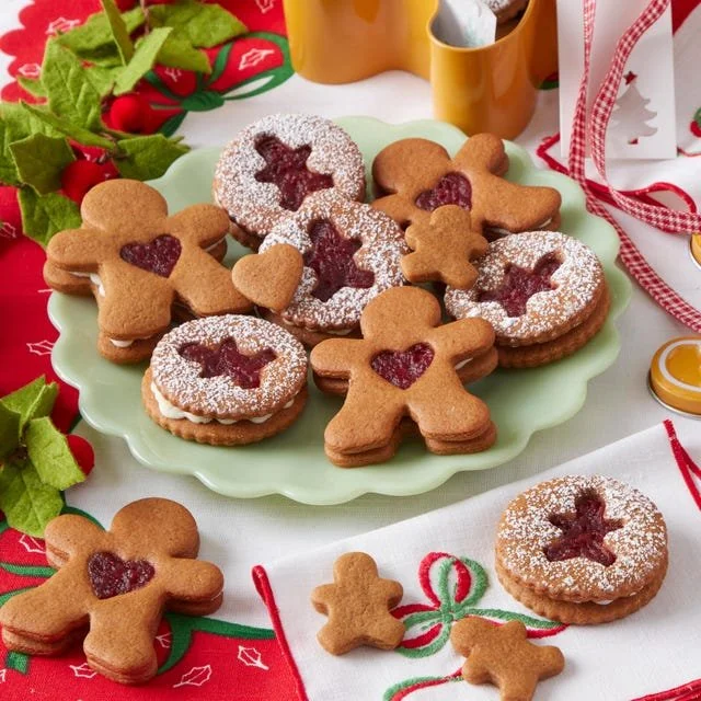 Homemade gingerbread cookie sandwiches filled with creamy frosting, decorated for the holidays