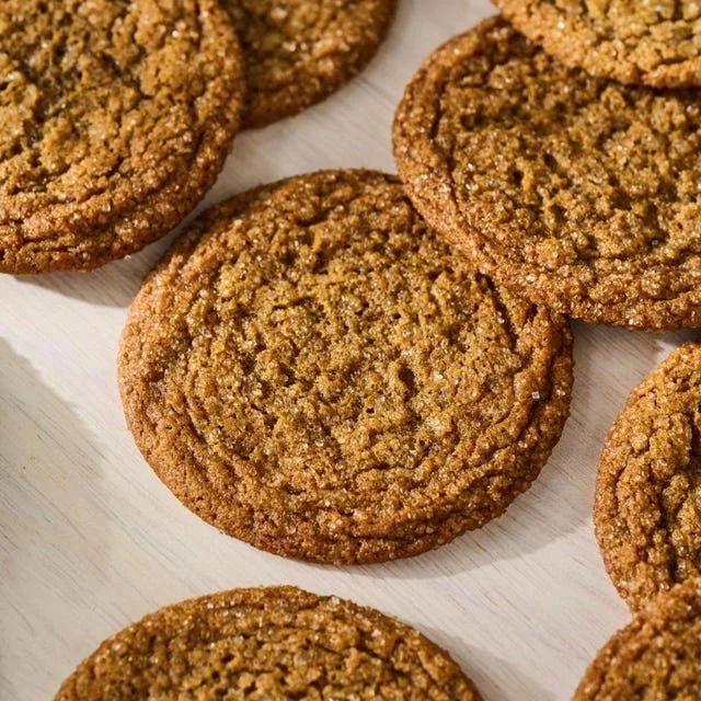Bowl of freshly baked gingersnaps cookies on a rustic wooden table