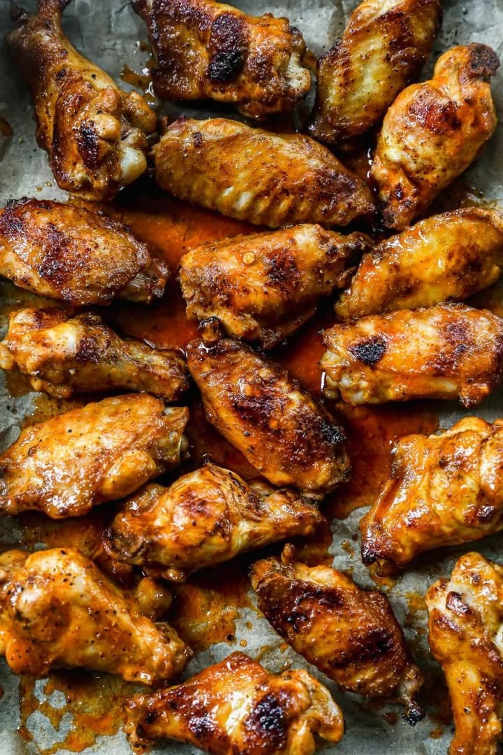 Delicious grilled chicken wings on a platter garnished with herbs