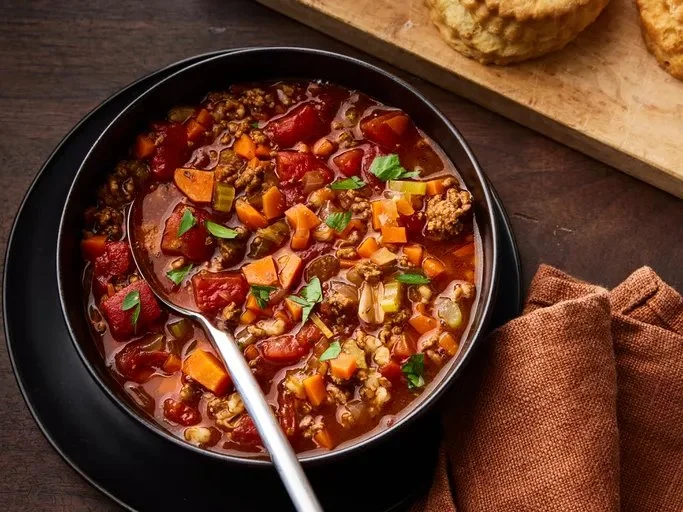 Bowl of hearty hamburger soup filled with vegetables and ground beef