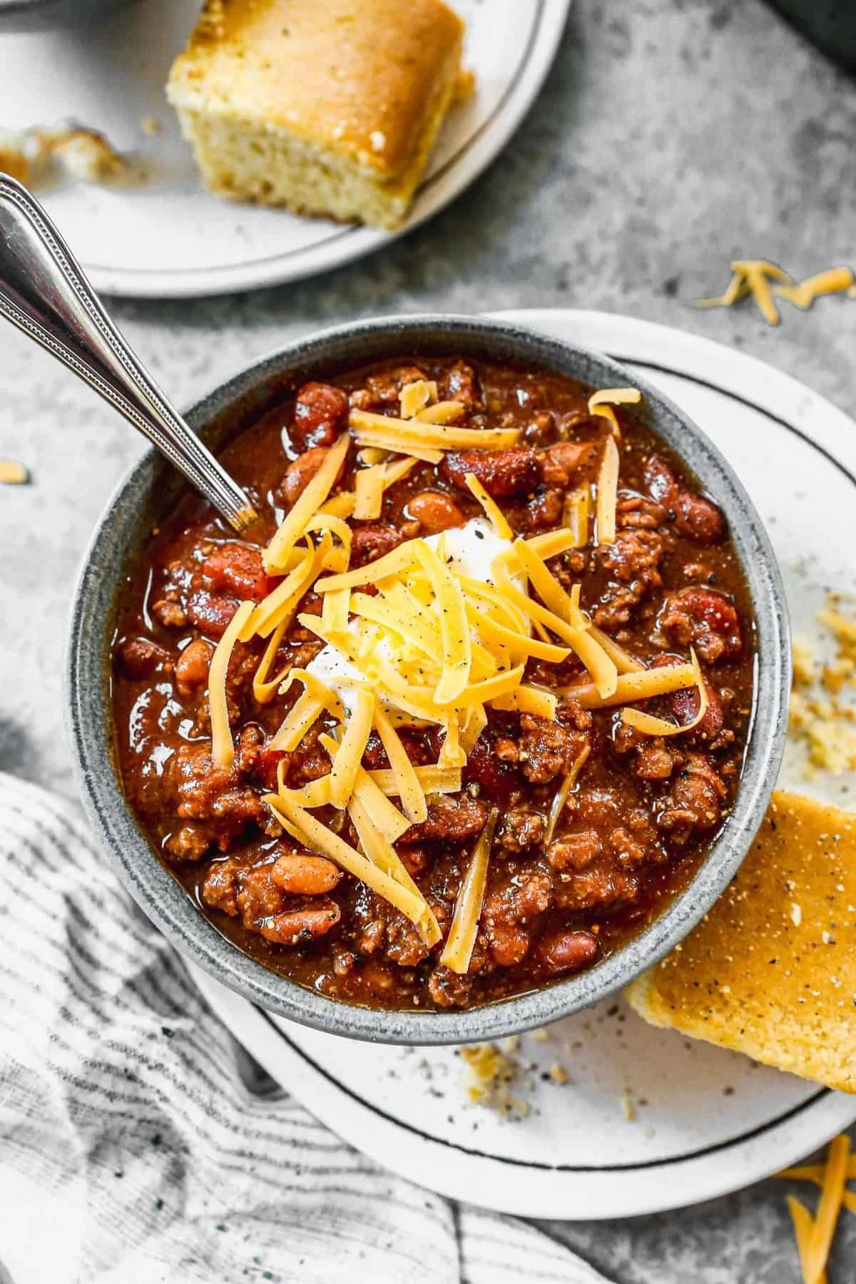 Bowl of homemade chili topped with cheese and fresh herbs.