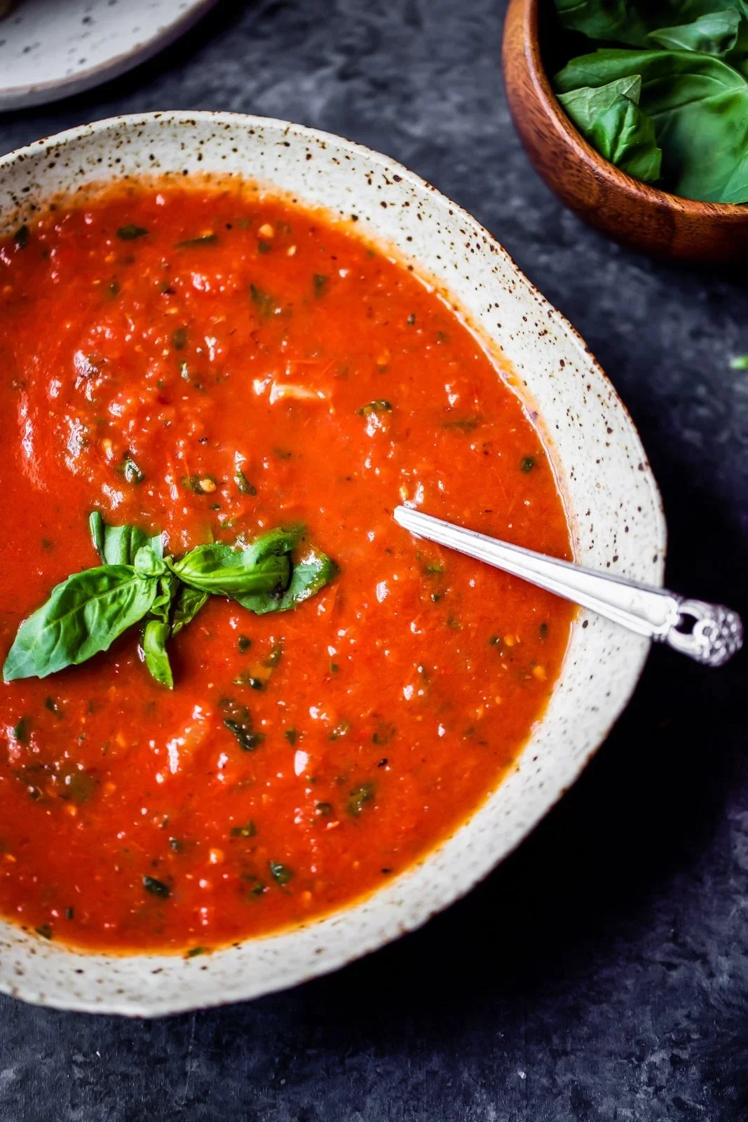 Bowl of homemade roasted tomato basil soup garnished with fresh basil leaves