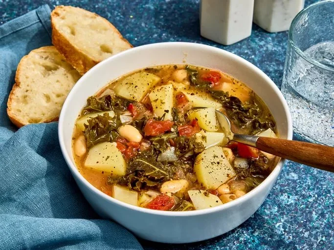 Bowl of healthy kale soup topped with herbs and spices