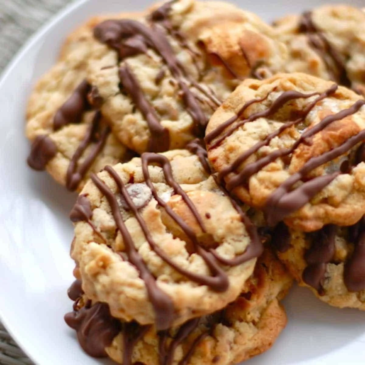 Plate of vibrant Marshmallow Monster Cookies with colorful candies and marshmallows.