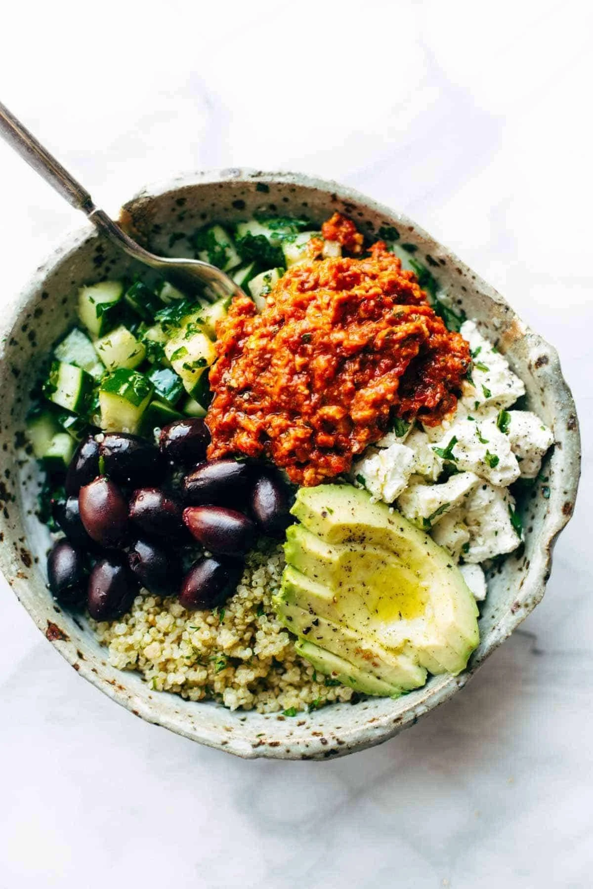 Mediterranean quinoa bowls with creamy roasted red pepper sauce served in a bowl