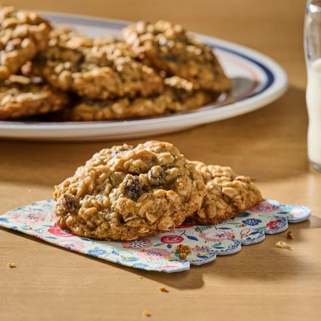 Homemade oatmeal raisin cookies on a rustic wooden table.