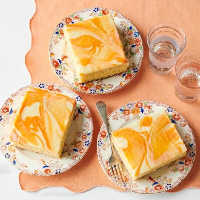 Freshly baked Orange-Vanilla Sheet Cake topped with orange slices and vanilla frosting.